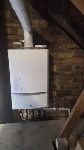 New Alpha boiler fitted on a brick loft wall with the flue running up