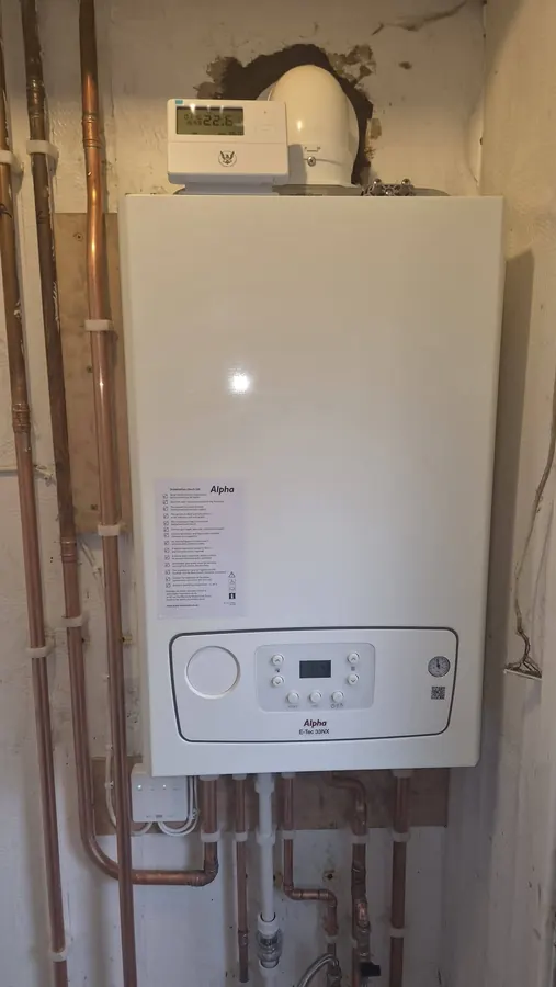 New white Alpha combi boiler with neatly clipped copper pipes