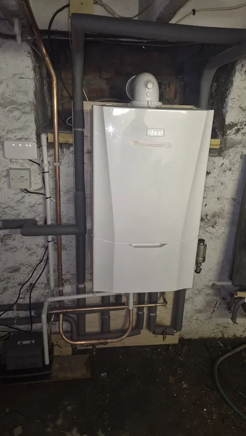 New Ideal boiler on a stone basement wall with lagged pipework